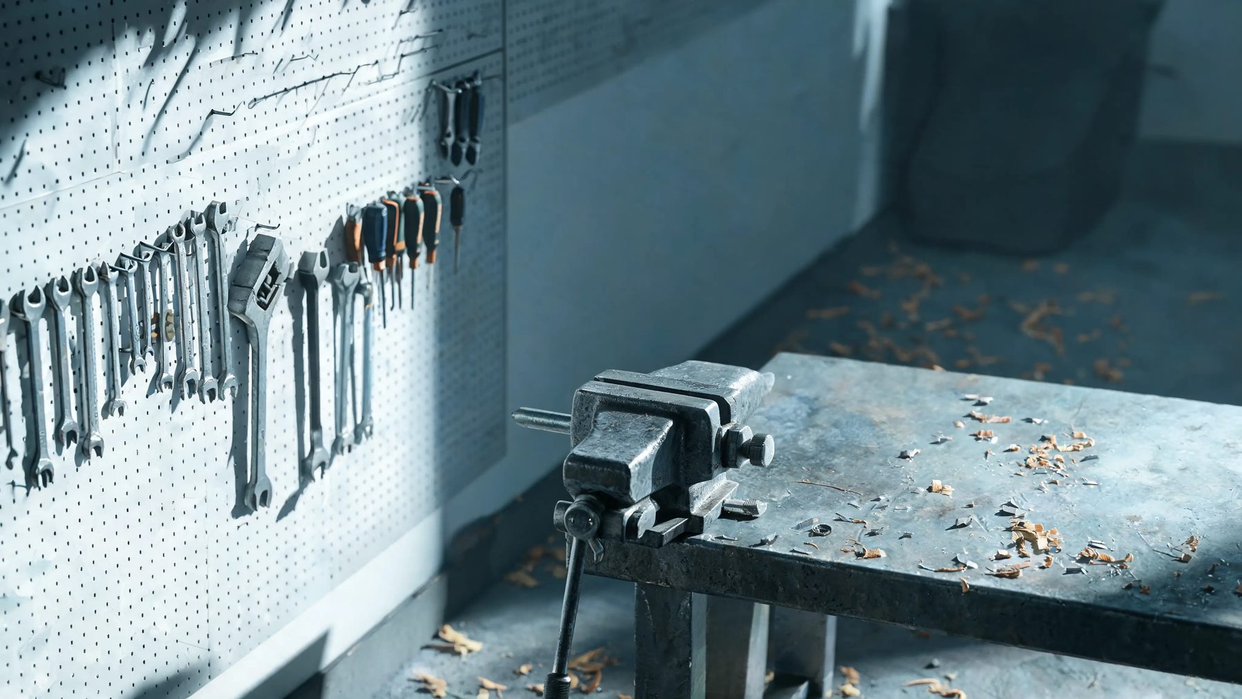 Shop corner with a pegboard wall, a bench vice and shavings on the floor